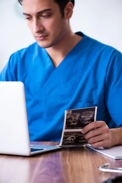 Молодой врач-мужчина смотрит на доплеровские изображения — стоковое фото