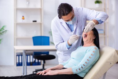 Yaşlı kadın genç dişçiyi ziyaret ediyor.