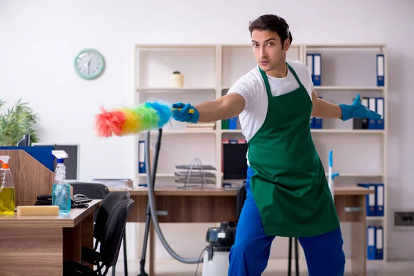 Fiatal jóképű vállalkozó takarítja az irodát — Stock Fotó