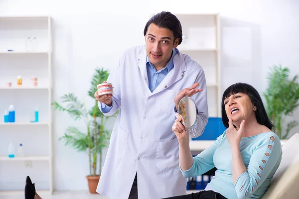 Oude vrouw bezoekt jonge dokter tandarts — Stockfoto