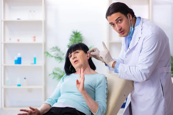 Oude vrouw op bezoek bij jonge arts laryngoloog — Stockfoto