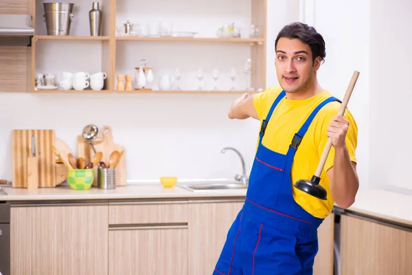 Jovem empreiteiro masculino reparando torneira em casa — Fotografia de Stock