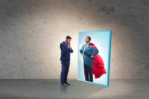 Businessman seeing himself in mirror as superhero