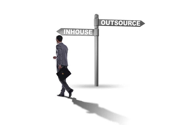 Businessman at crossroads deciding between outsourcing and inhou — Stock Photo, Image