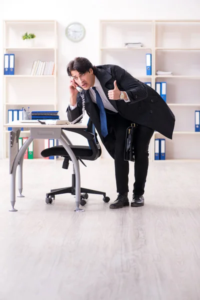 Ung manlig anställd på kontoret i time management koncept — Stockfoto