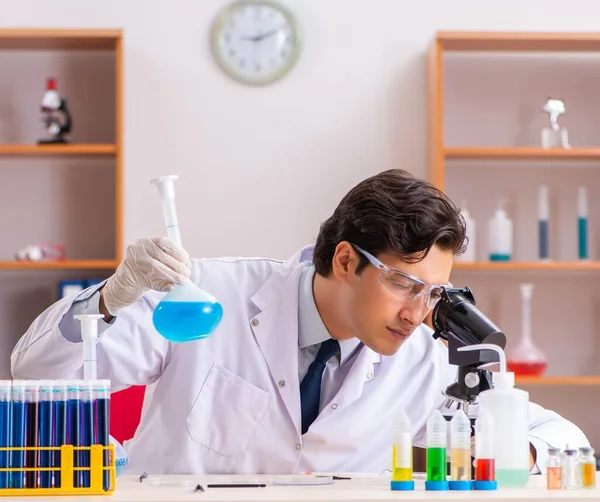 Jeune beau biochimiste travaillant dans le laboratoire — Photo