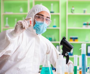 Laboratuvarda yeni bir deney üzerinde çalışan kimyager.