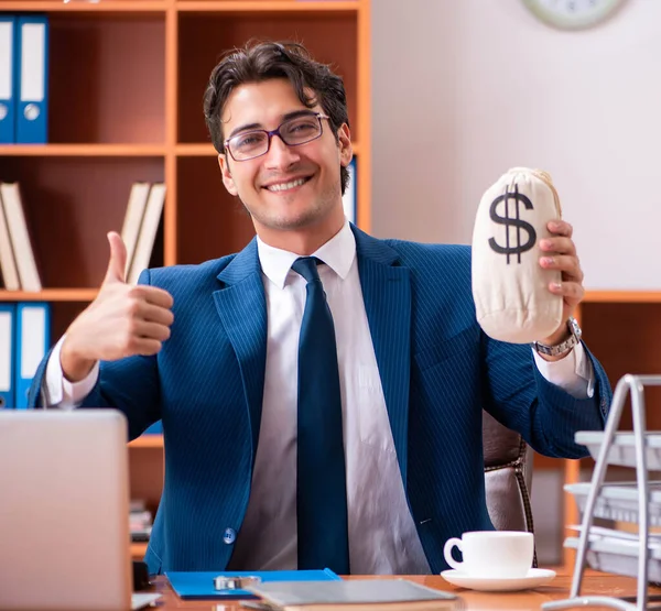 Genç yakışıklı işadamı ofiste çalışıyor.