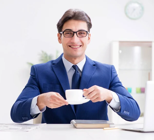 Joven hombre de negocios guapo tomando café en la oficina — Foto de Stock