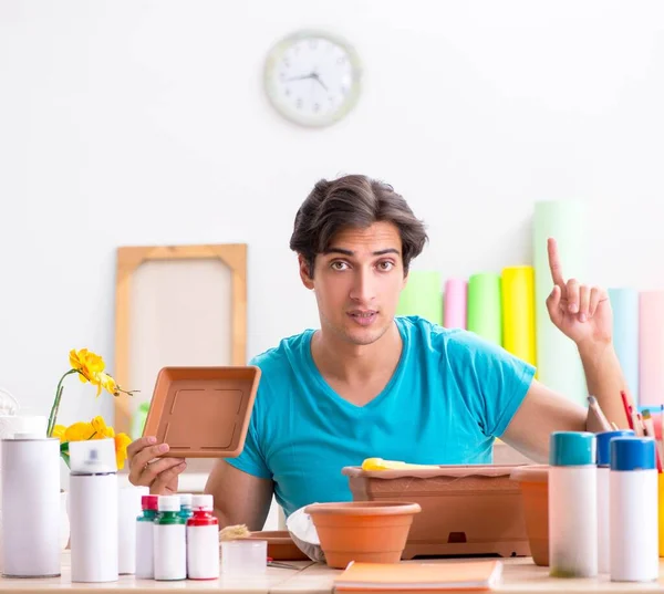 Young man decorating pottery in class — Stock Photo, Image