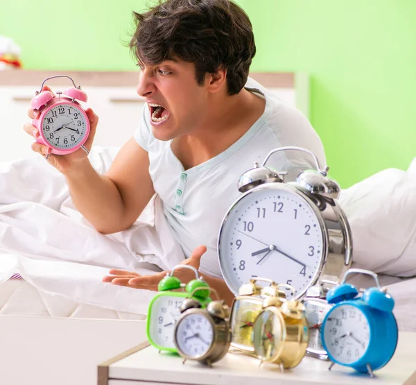 Young man having trouble waking up in early morning