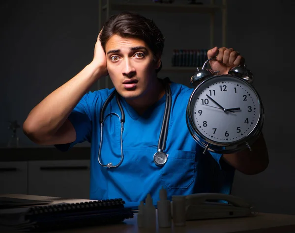 Joven médico guapo trabajando turno de noche en el hospital —  Fotos de Stock