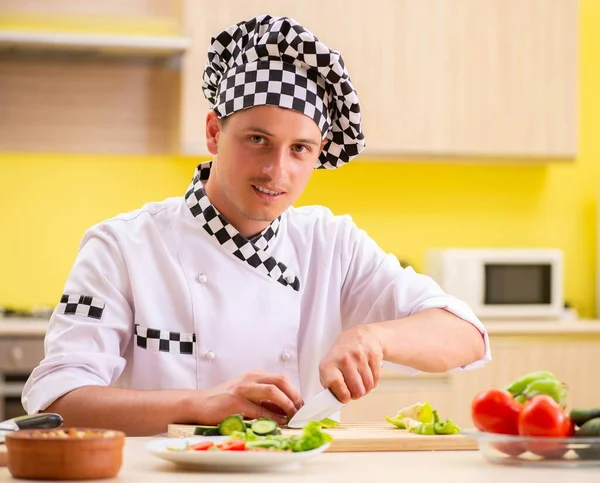 Jeune cuisinier professionnel préparant la salade à la cuisine — Photo