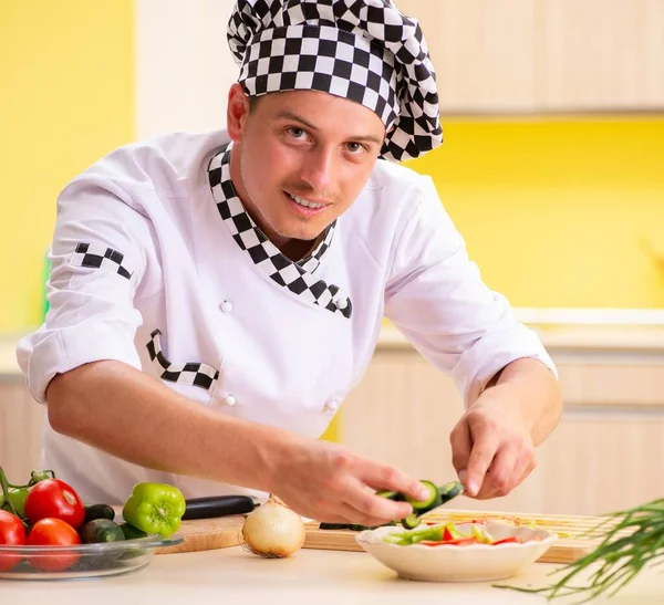 Joven cocinero profesional preparando ensalada en la cocina —  Fotos de Stock