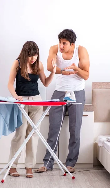 Mujer joven haciendo planchado para su marido —  Fotos de Stock