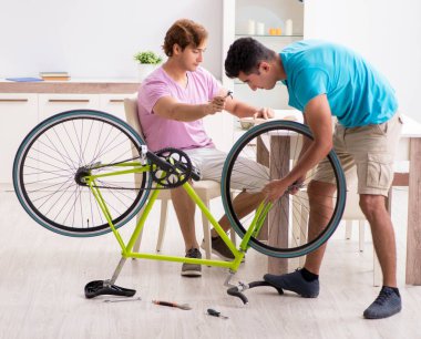 Kırık bisikletini tamir eden adam.