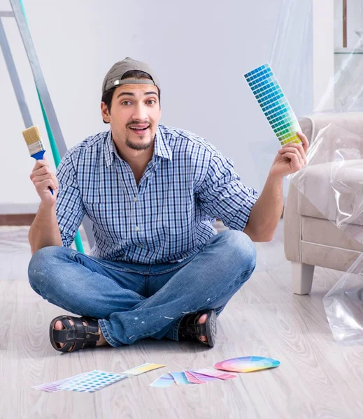 Young man contractor choosing color from rainbow — Stock Photo, Image