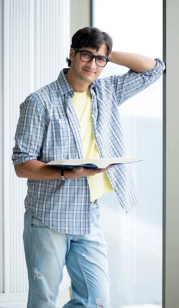 Joven estudiante guapo de pie en la ventana —  Fotos de Stock