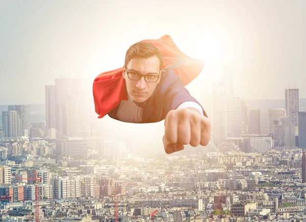 Superhero businessman flying over the city