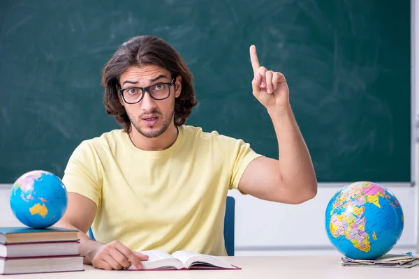 Jovem professor de geografia do sexo masculino na frente do quadro negro — Fotografia de Stock