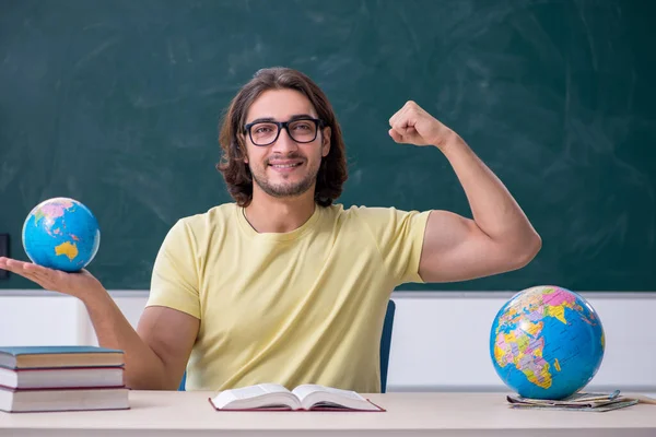 Jovem professor de geografia do sexo masculino na frente do quadro negro — Fotografia de Stock