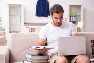 Evde sınava hazırlanan genç bir erkek öğrenci.