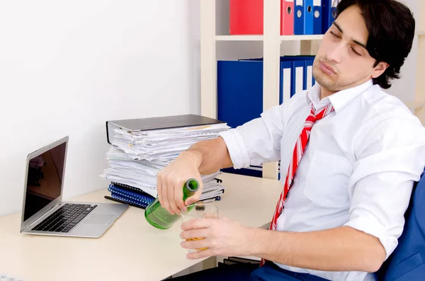 Young businessman employee drinking in the office — Stock Photo, Image