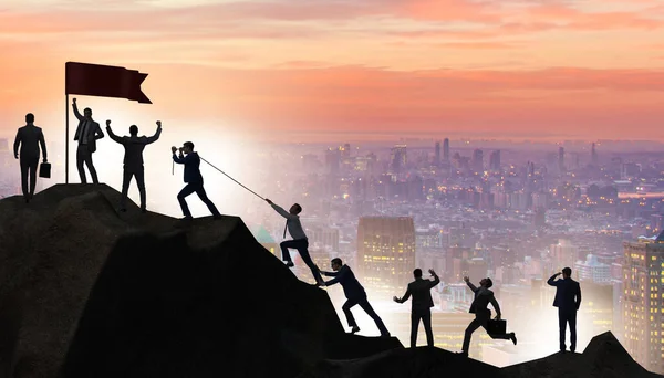 Concept of teamwork with team climbing mountain top — Stock Photo, Image