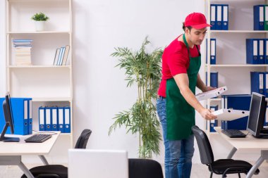 Genç erkek kurye ofise pizza getiriyor.