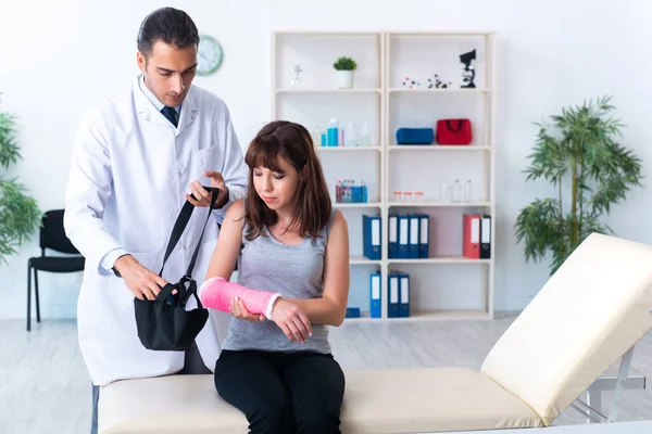 Mujer joven visitando médico traumatólogo masculino —  Fotos de Stock