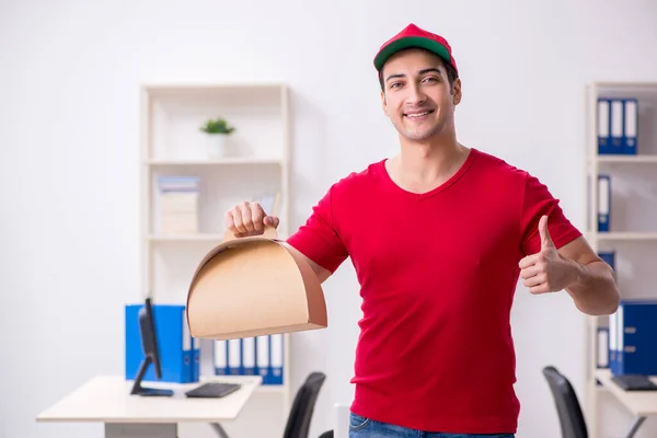 Young male courier delivering cake to the office