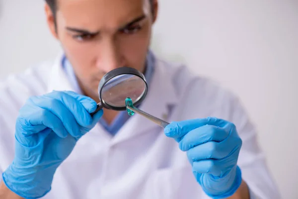 Jovem assistente de laboratório no conceito de síntese de drogas — Fotografia de Stock