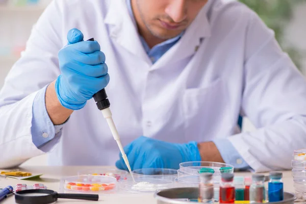 Jovem assistente de laboratório no conceito de síntese de drogas — Fotografia de Stock