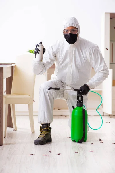Jovem empreiteiro fazendo controle de pragas em casa — Fotografia de Stock