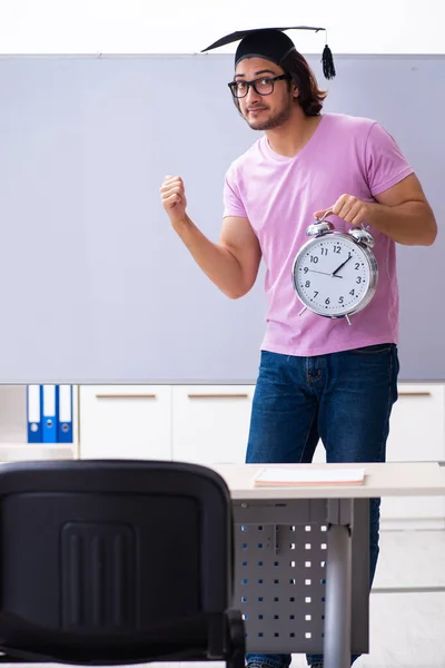 Joven estudiante masculino en concepto de gestión del tiempo —  Fotos de Stock