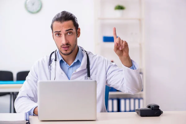 Joven guapo médico masculino que trabaja en la clínica —  Fotos de Stock