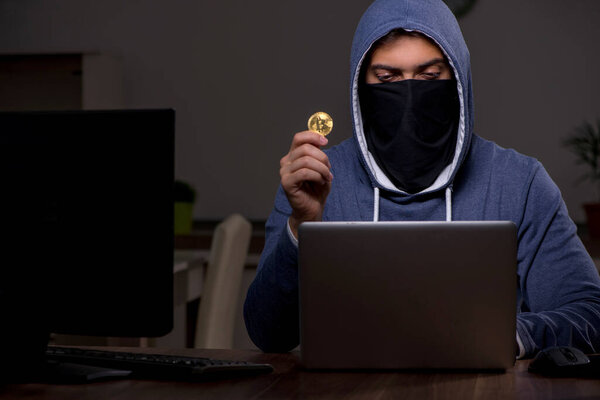 Male hacker hacking security firewall late in office