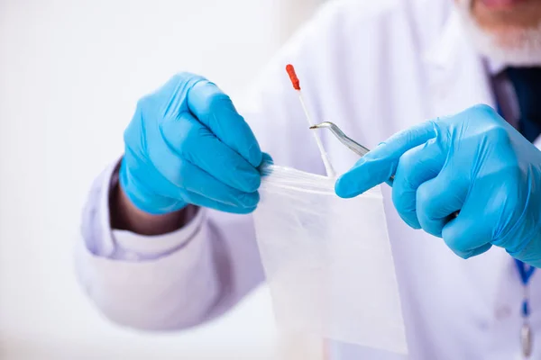 Viejo criminólogo experto trabajando en el laboratorio como evidencia — Foto de Stock