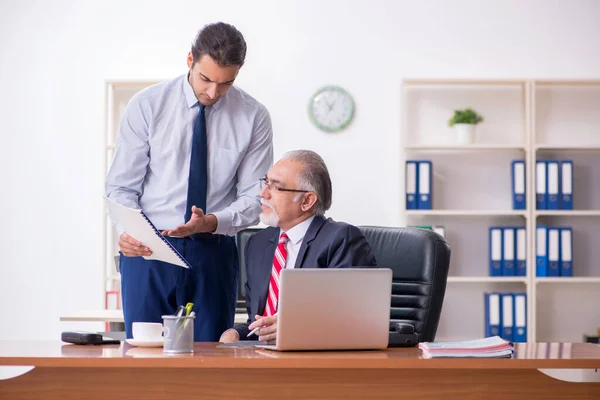 Old boss and young male employee in the office — Stock Photo, Image