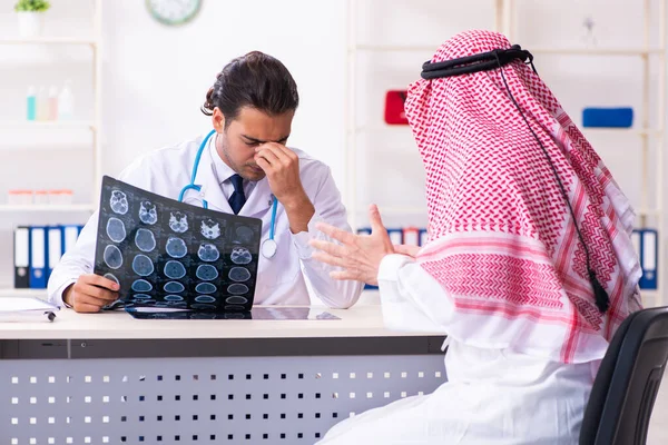 Old male arab visiting young male doctor — Stock Fotó