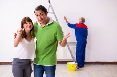 Genç çift ve ev yenileme konseptinde yaşlı müteahhit.