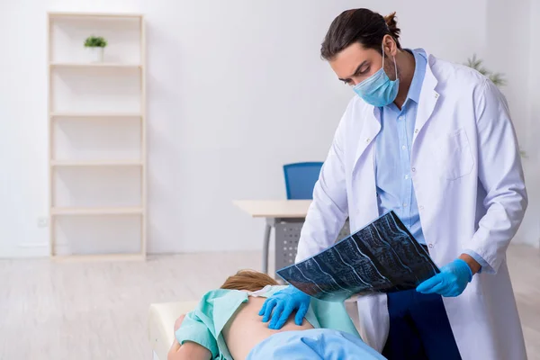 Young back injured woman visiting male doctor chiropractor — Stock Photo, Image