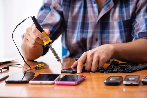 Ung manlig tekniker reparera mobiltelefon — Stockfoto
