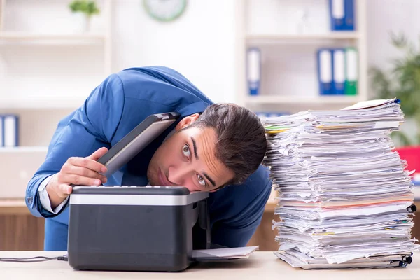 Young male employee making copies at copying machine Royalty Free Stock Photos