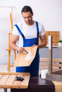 Genç erkek müteahhit atölyede çalışıyor.