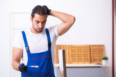 Genç erkek müteahhit atölyede çalışıyor.