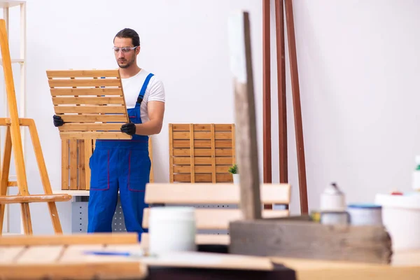 Jonge mannelijke aannemer werkzaam in werkplaats — Stockfoto