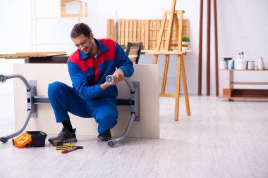 Genç erkek müteahhit atölyede çalışıyor.