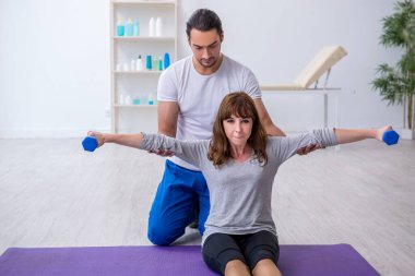 Kişisel koçla spor egzersizleri yapan genç bir kadın.