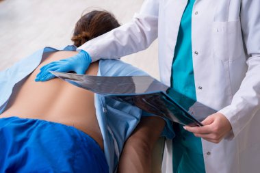 Genç sırtı yaralı bir adam, kadın doktor masörünü ziyaret ediyor.